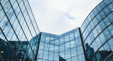 Imagem de um prédio comercial com o céu ao fundo.